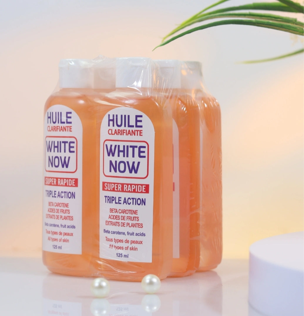 Two bottles of 'White Now' clarifying oil on a light background